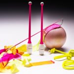 Accessories for rhythmic gymnastics ball, clubs, ribbon, rope lie on the floor.